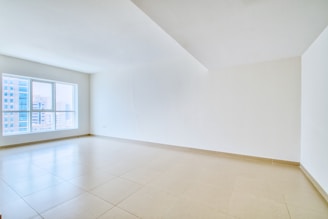 A spacious, empty room with a large window.