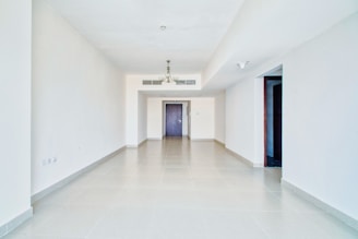 Empty and spacious white room with doorways.