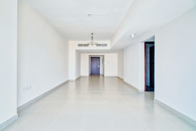 Empty and spacious white room with doorways.