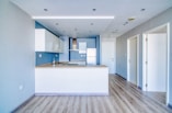 A modern kitchen and living space are shown.