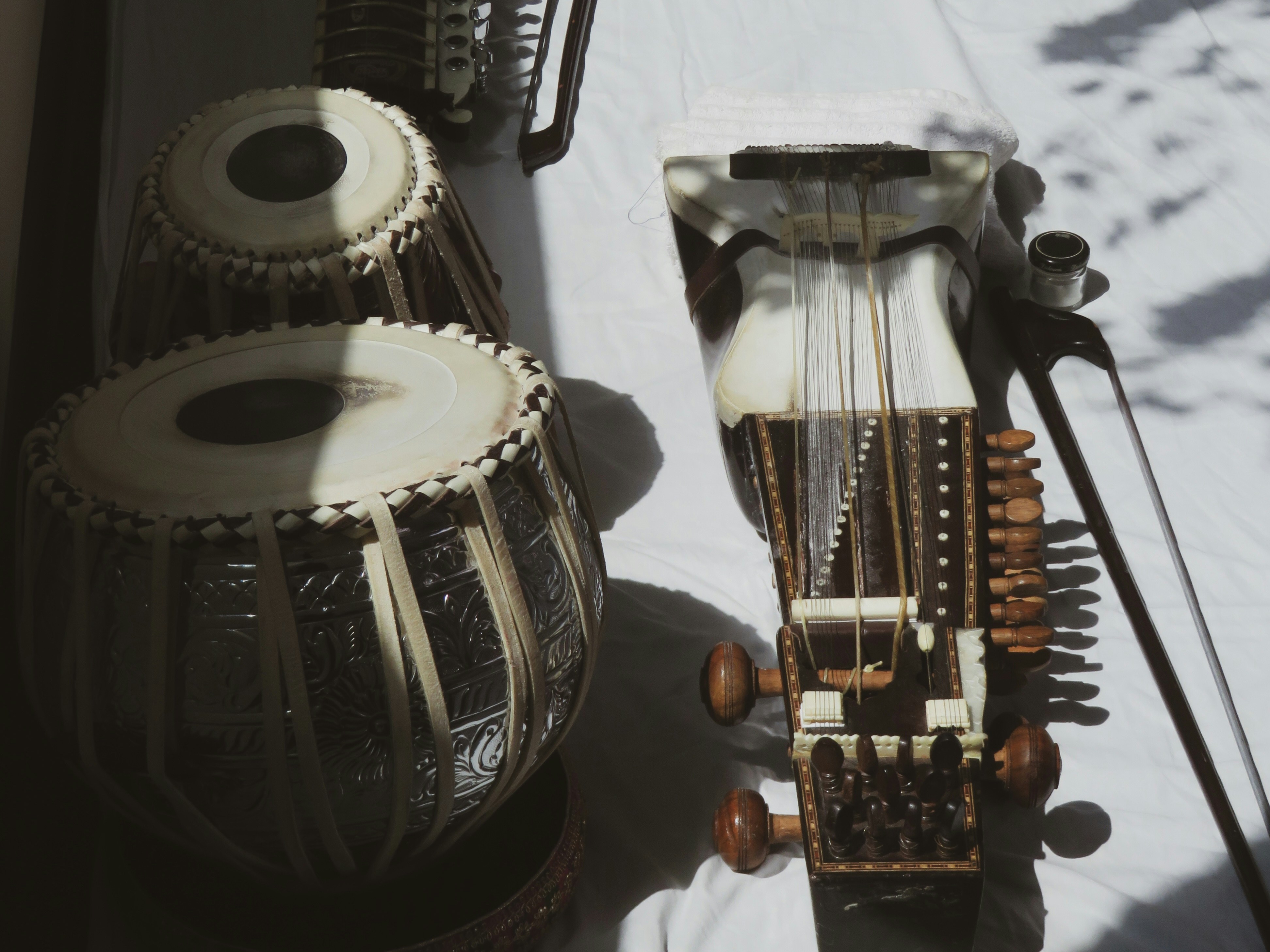 Indian musical instruments are displayed on a white surface.