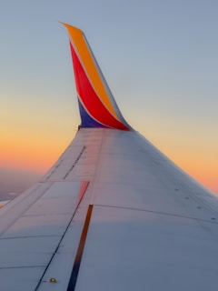 A southwest airplane wing against a sunset.