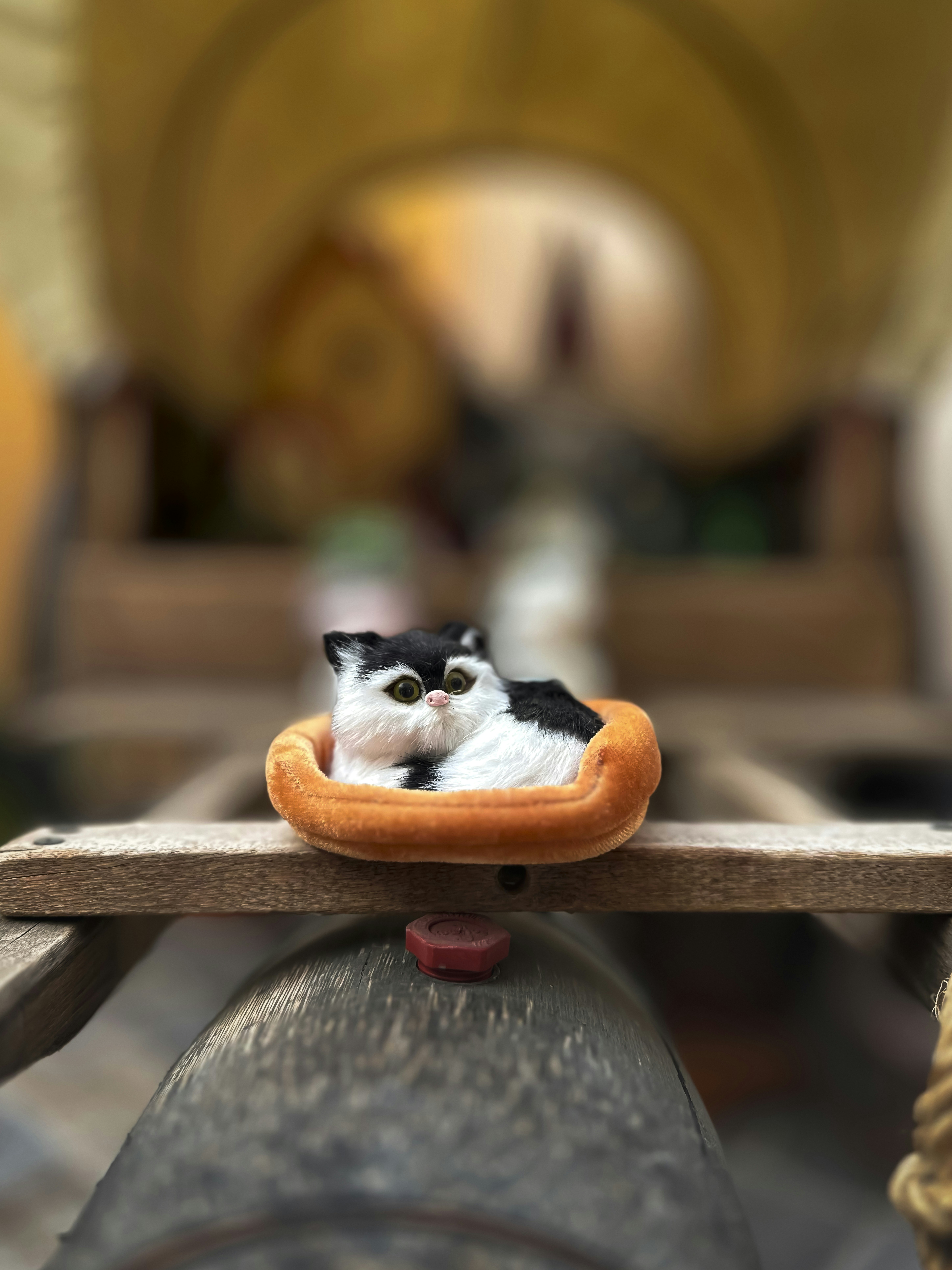A cute cat figurine rests inside a wagon.