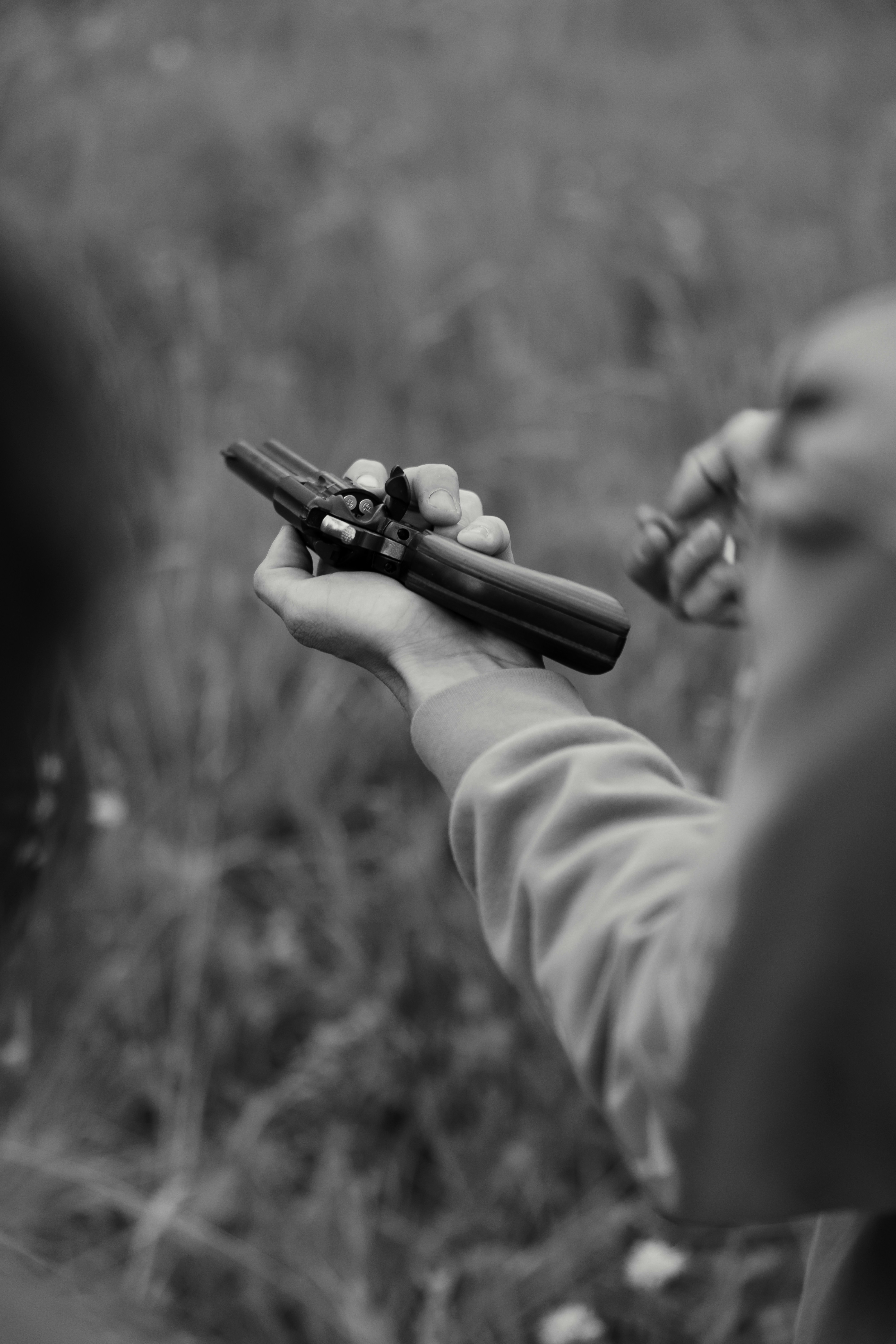 Someone is holding a gun outdoors.