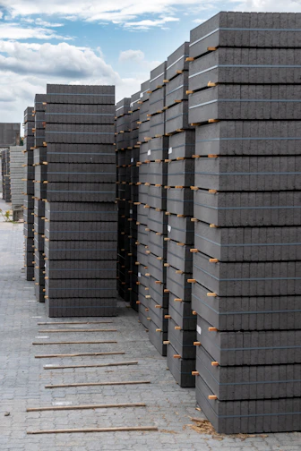 Stacks of gray pavers are neatly arranged outdoors.