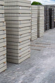 Piles of concrete paving stones are stacked neatly.
