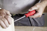 A person uses a screwdriver to build.