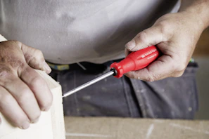 A person uses a screwdriver to build.