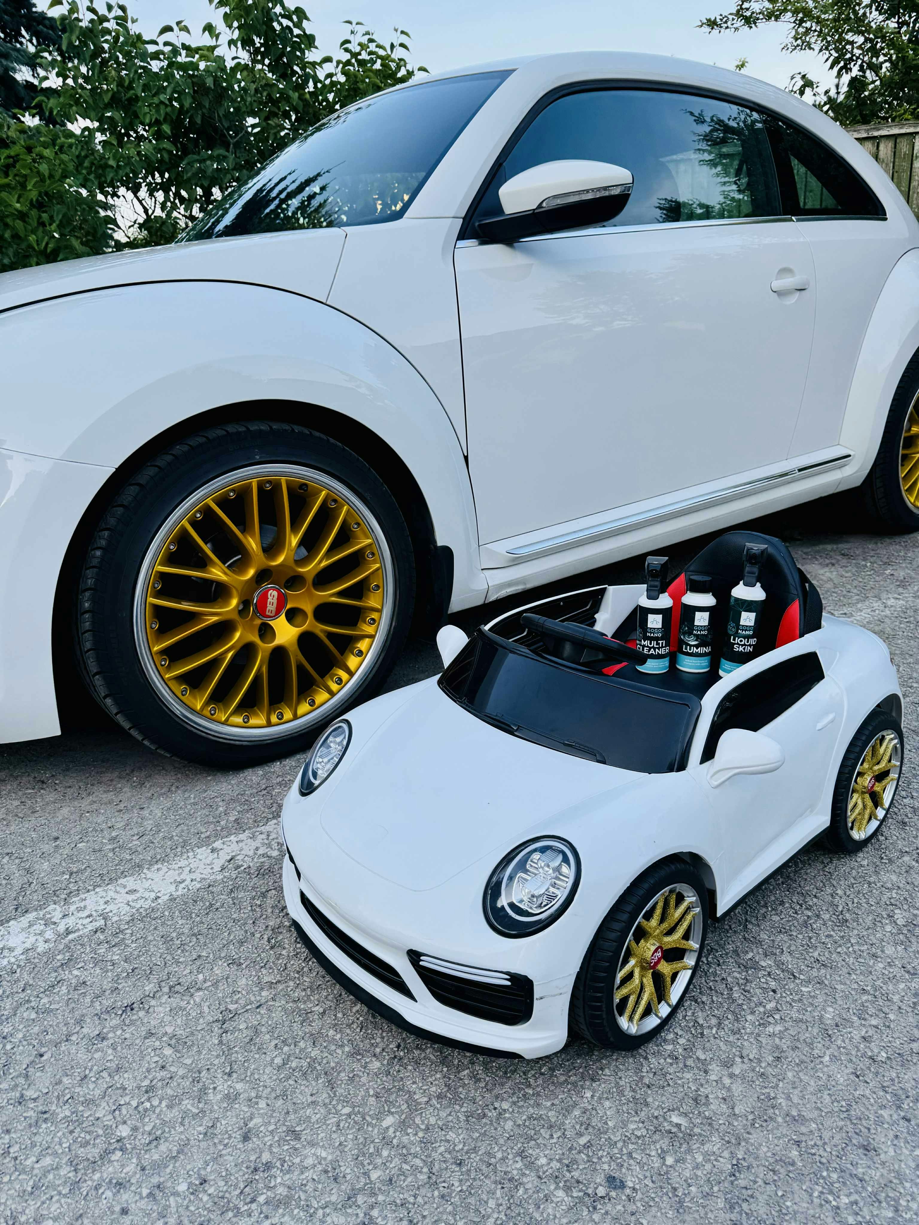 Um grande carro branco e sua versão em miniatura.