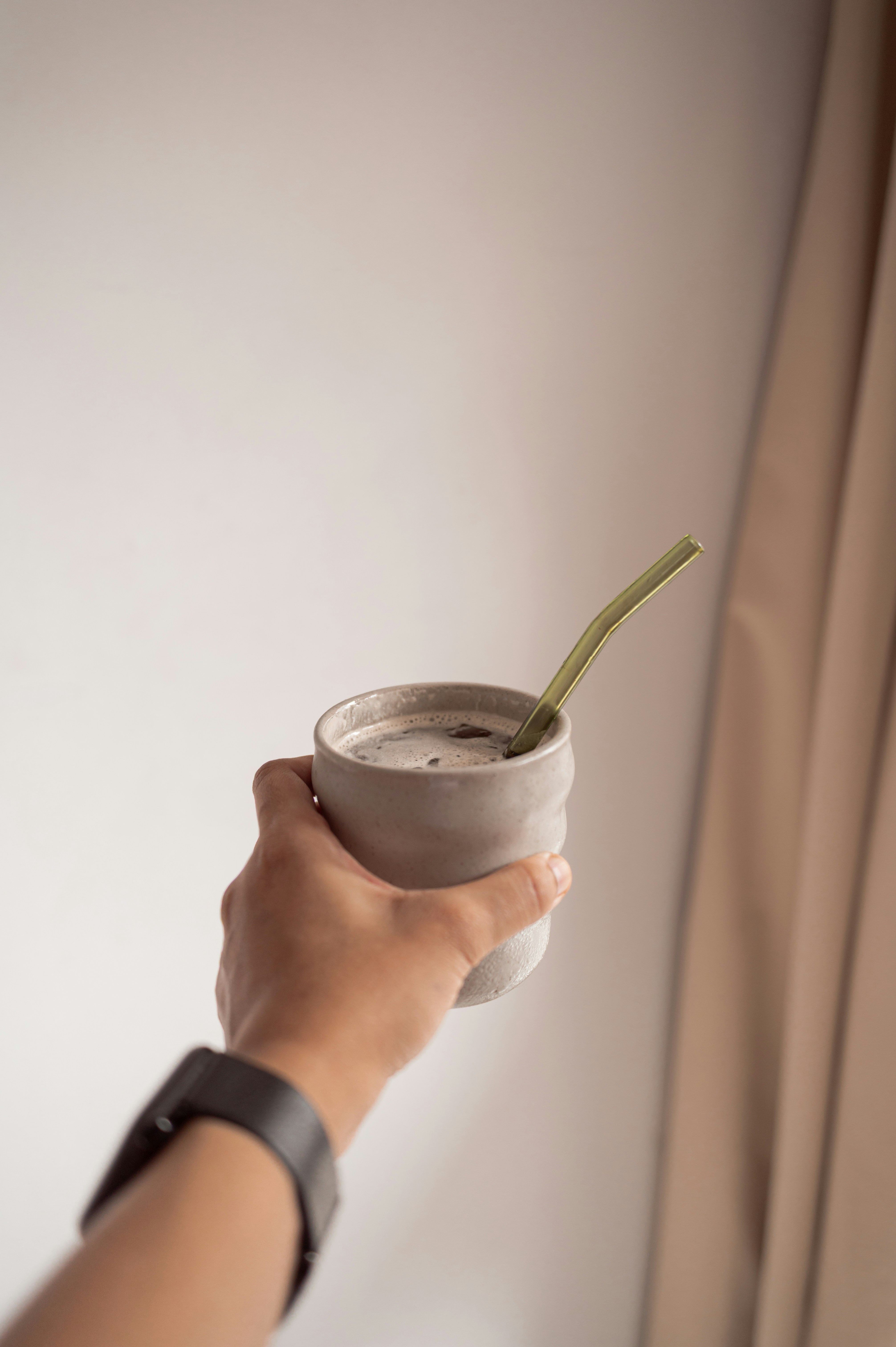 Die Hand hält eine Tasse Yerba Mate.