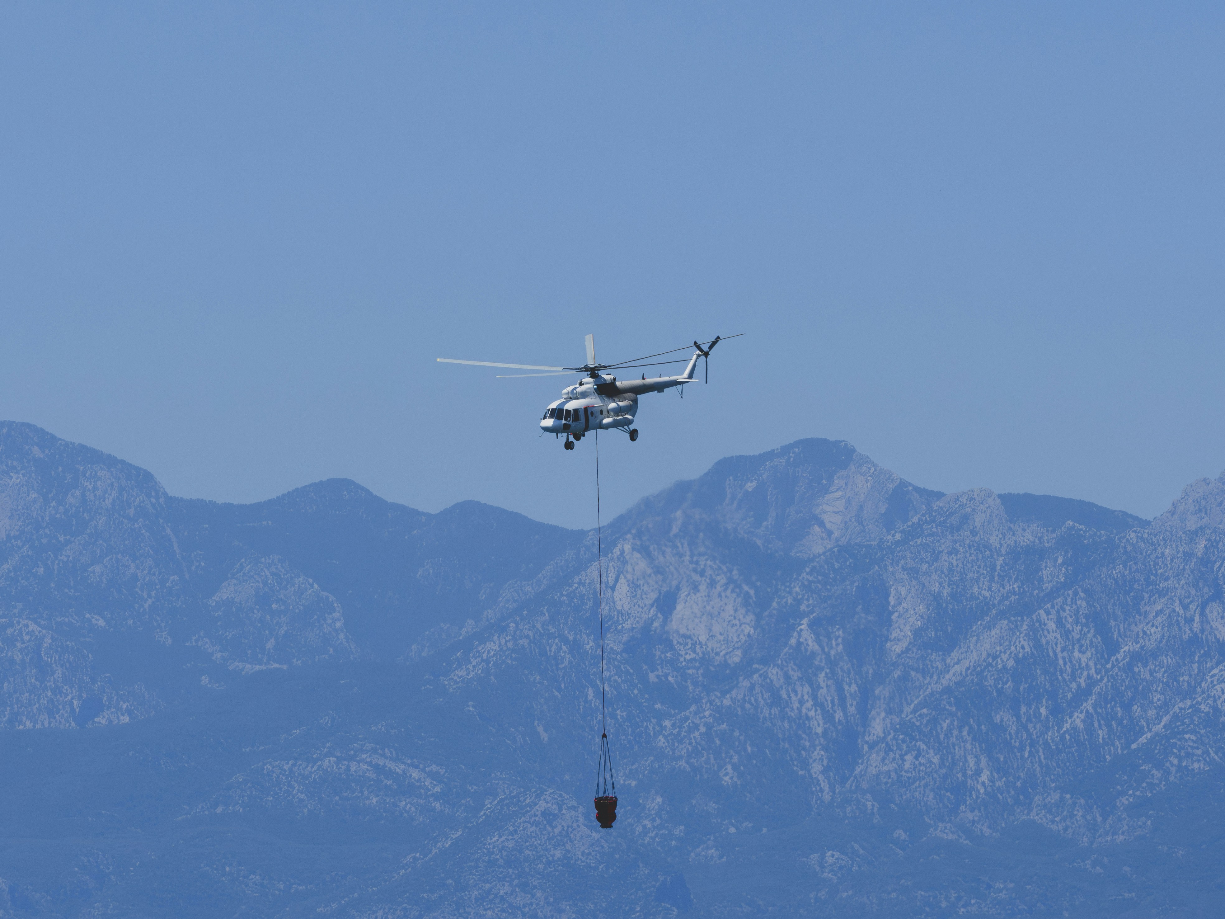 A helicopter carries water to fight a wildfire.