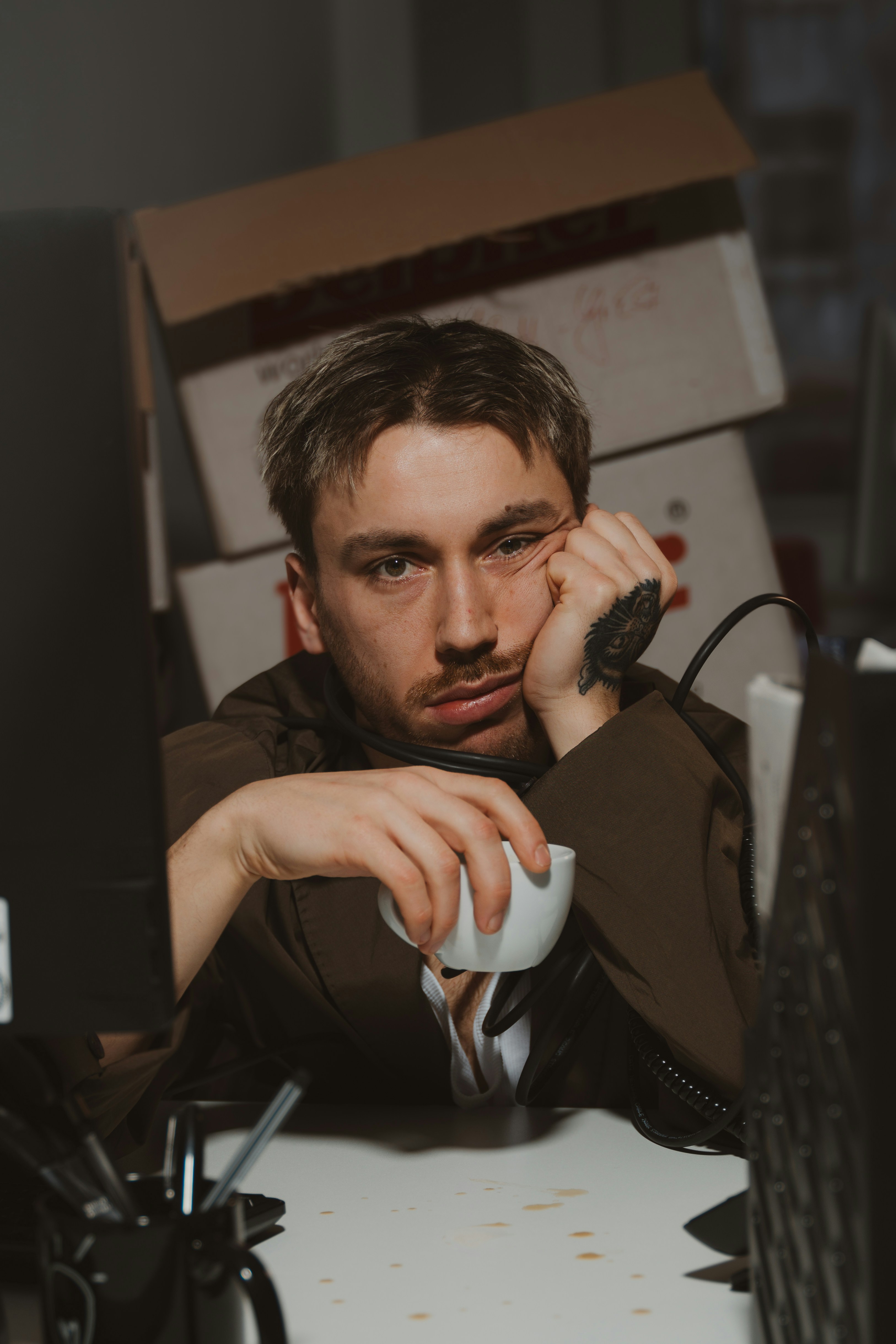 Man is bored and holding a coffee cup.
