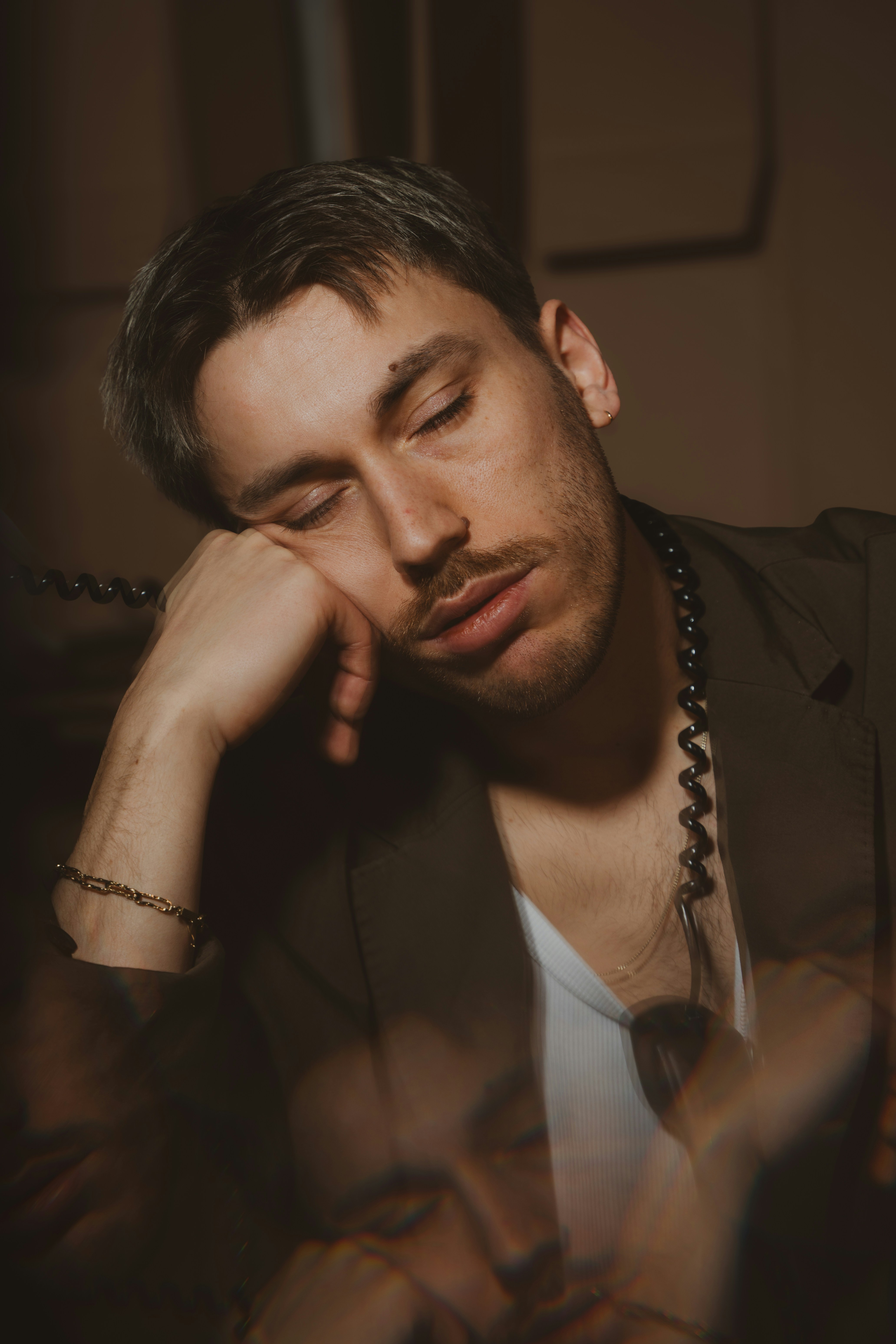 A man rests his head with closed eyes.