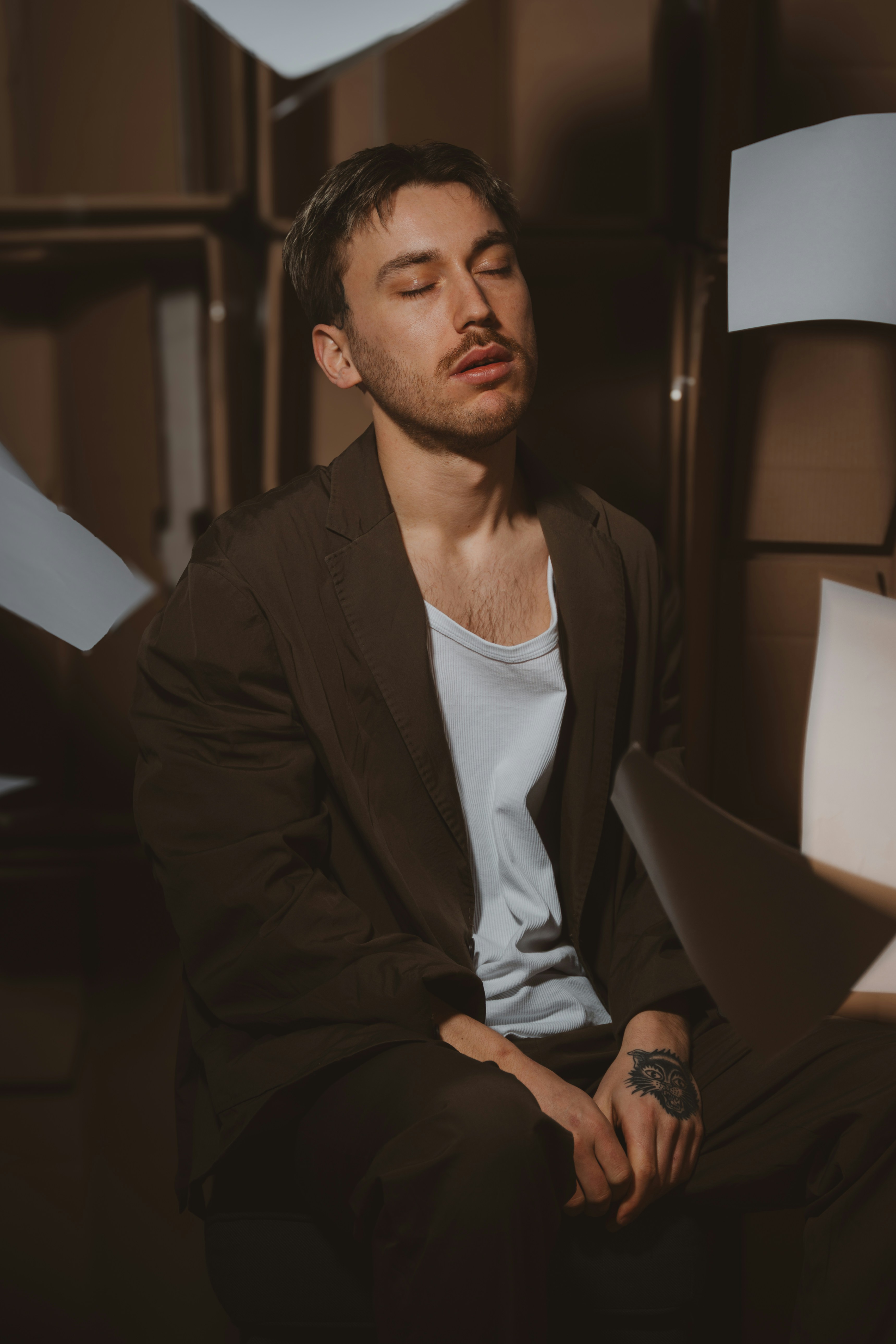 A man is surrounded by papers and boxes.