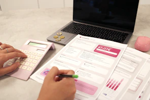 Someone is calculating their finances with documents.
