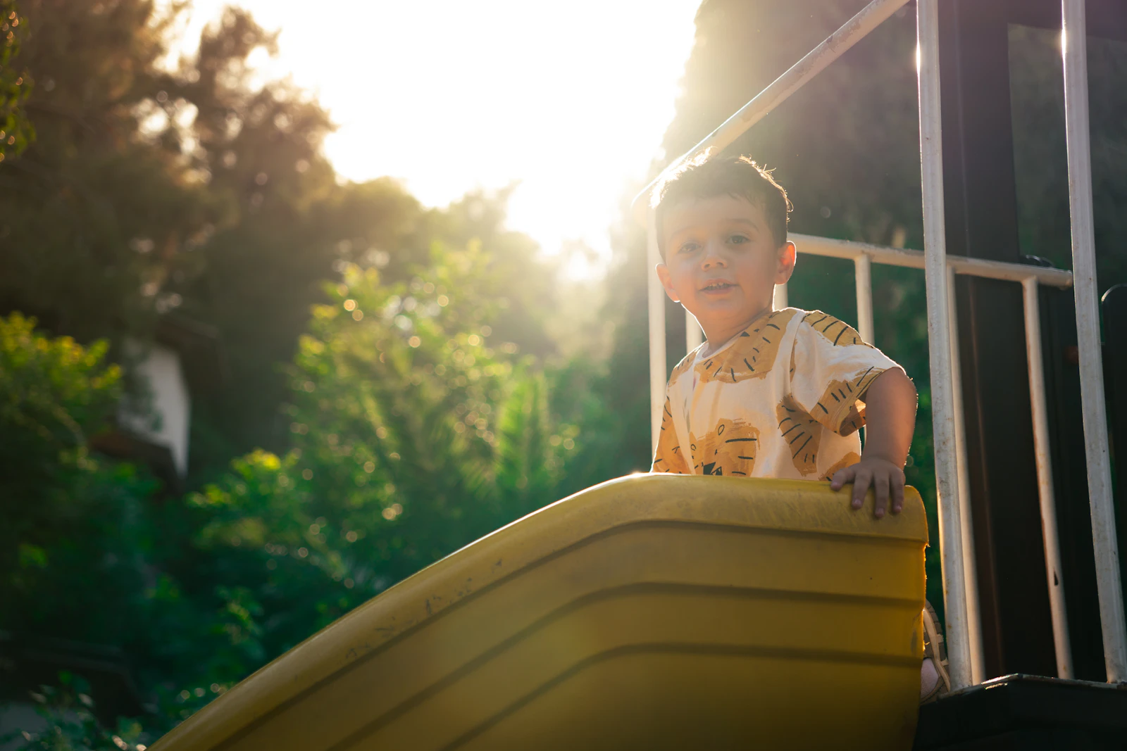 A happy child plays on a playground slide