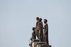 Statues of figures stand atop a building.