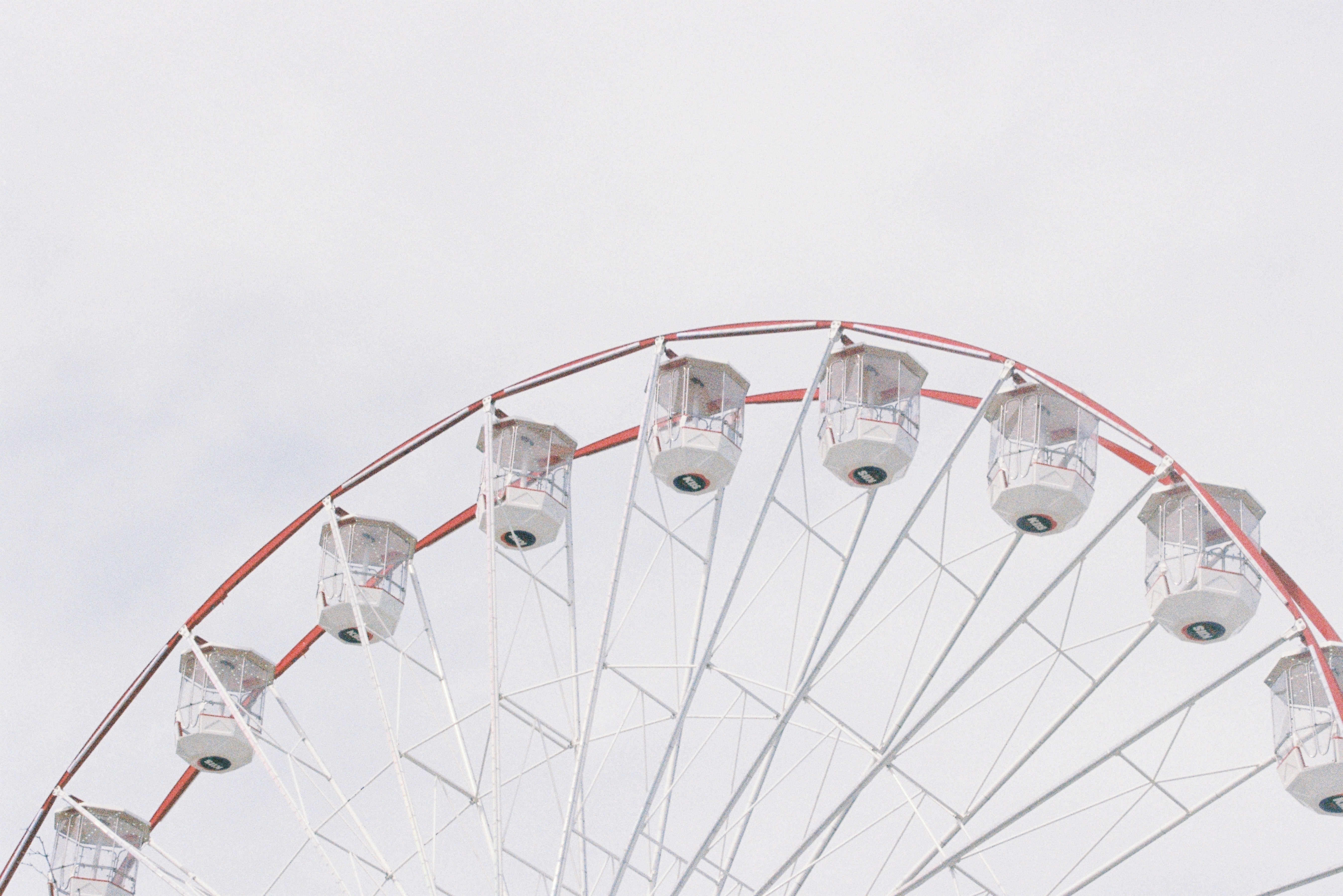 A ferris wheel against a cloudy, white sky.