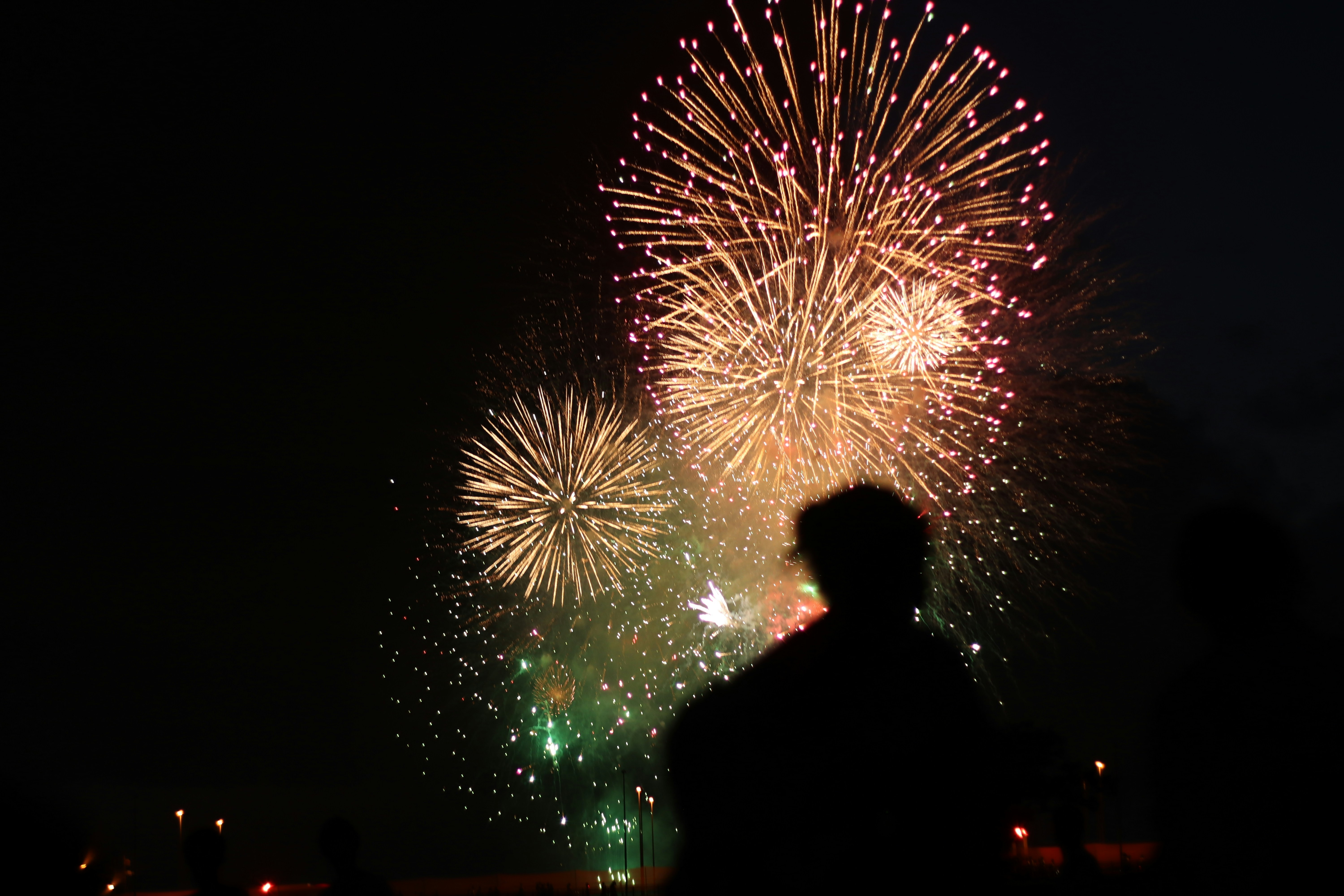A person watches a fireworks display.