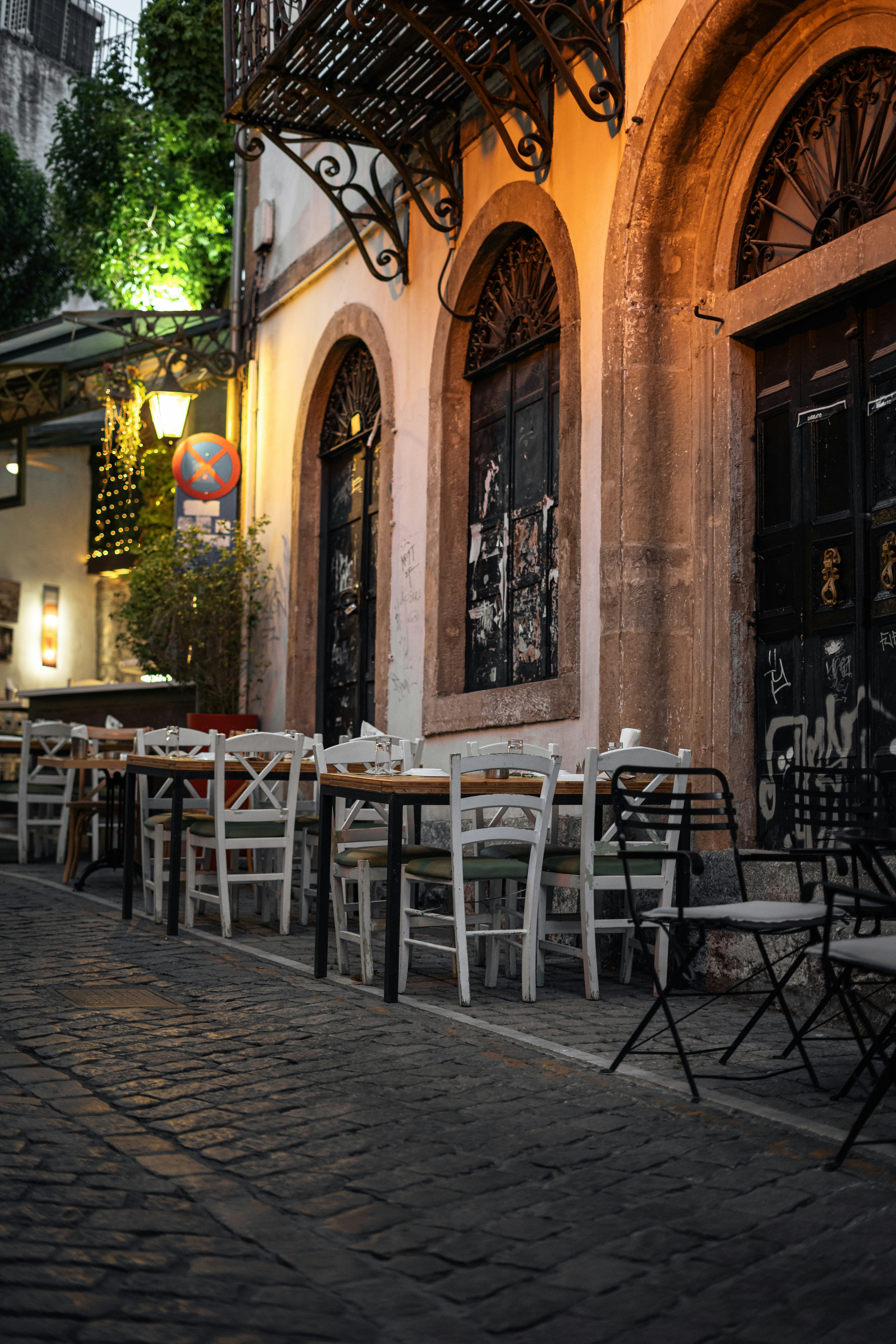A cozy restaurant facade along a cobbled street.