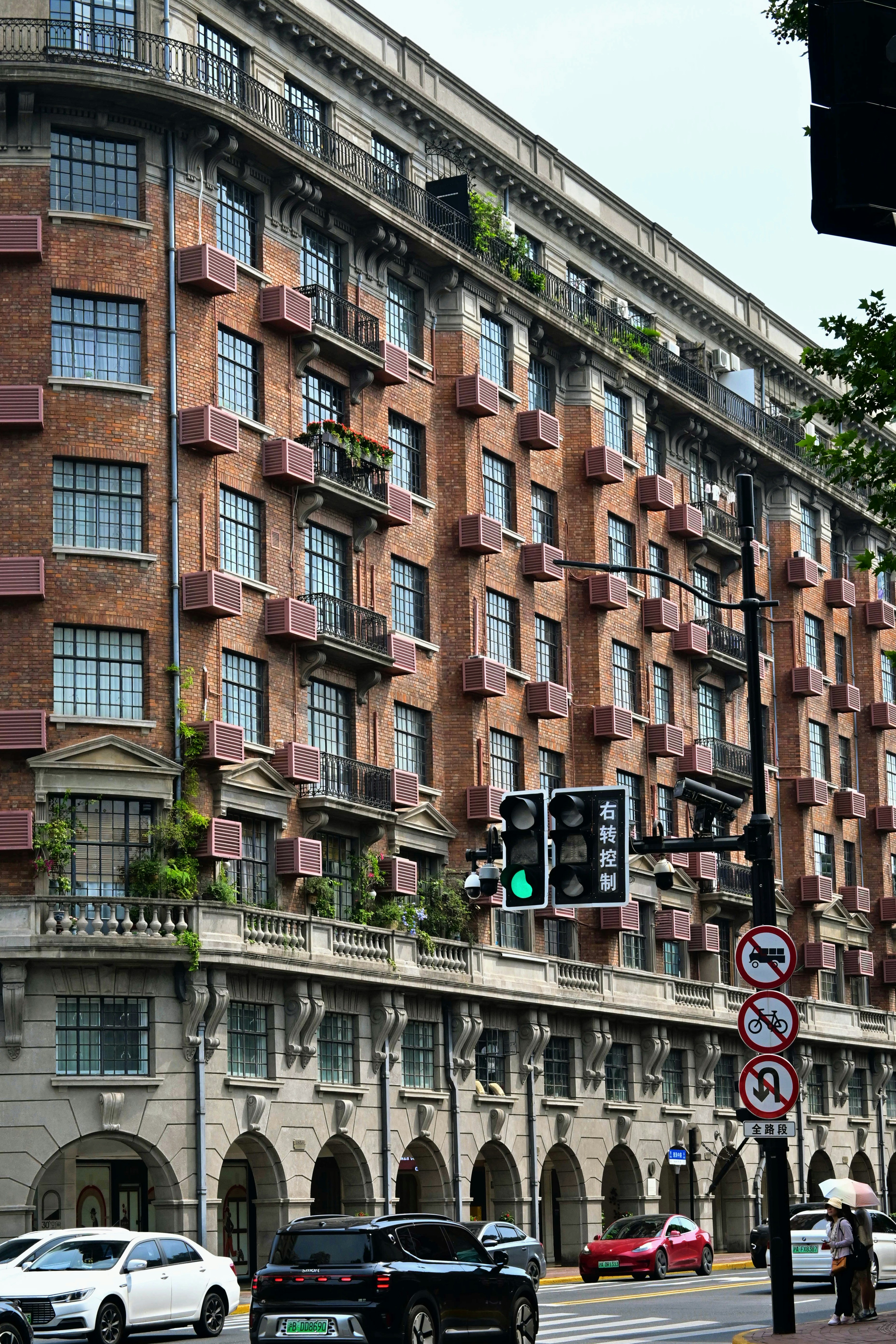 A stately brick building stands along a bustling street. photo – Free ...