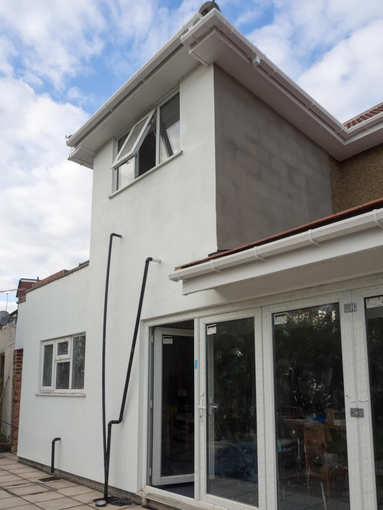 Residential building extension under construction with new walls and windows