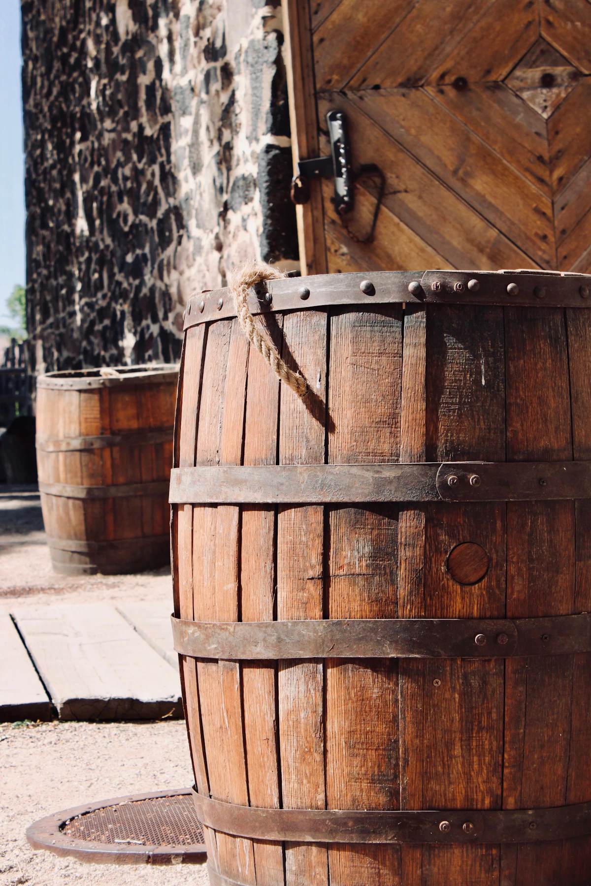 Oak barrels standing outside a weathered stone building