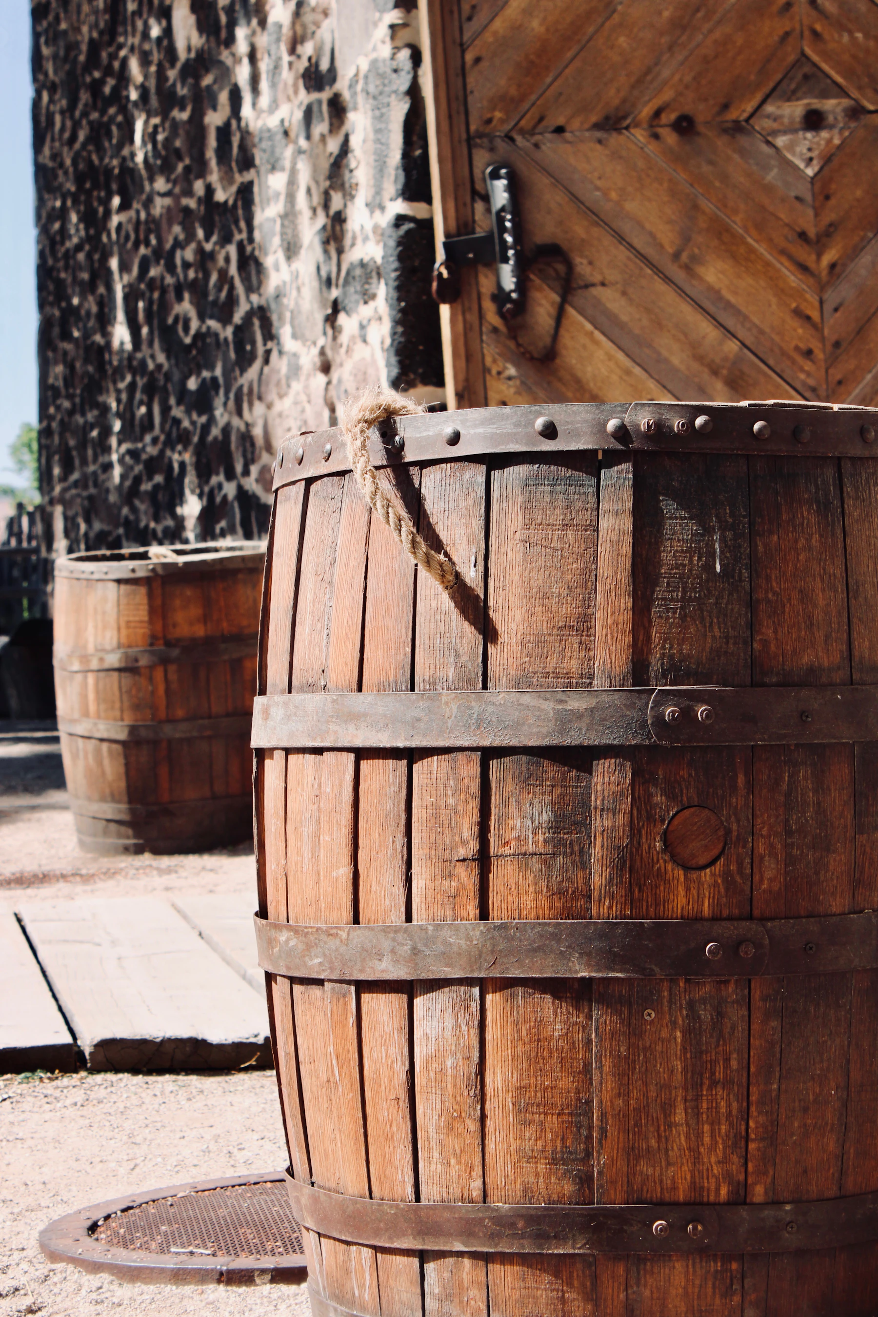 Oak barrels standing outside a weathered stone building