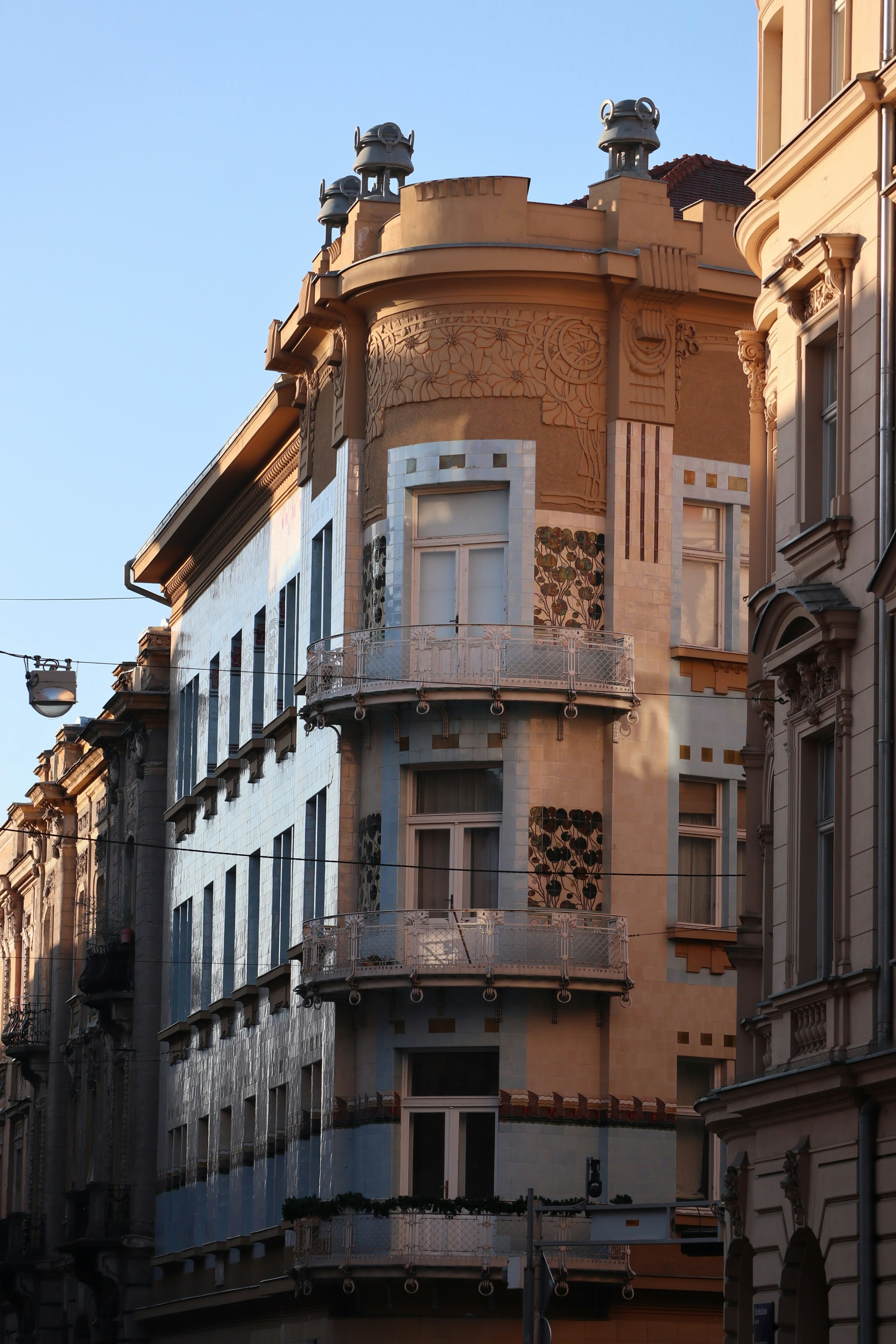 An ornate, art nouveau building graces a street.