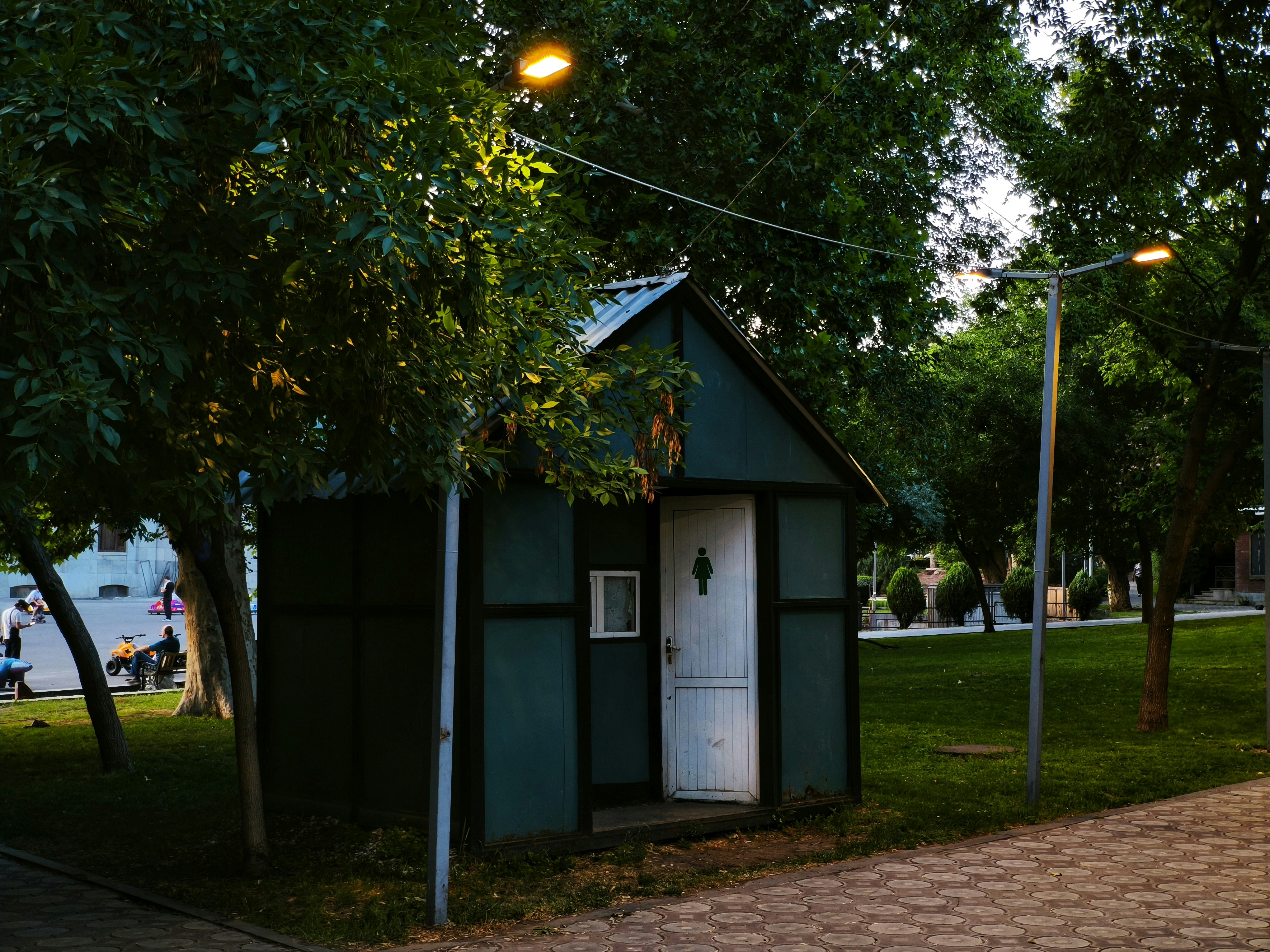 A public restroom sits in a park setting.