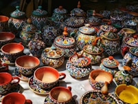 Many colorful ceramic teacups and teapots are on display.
