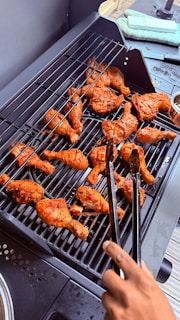 Grilled chicken drumsticks are being cooked.