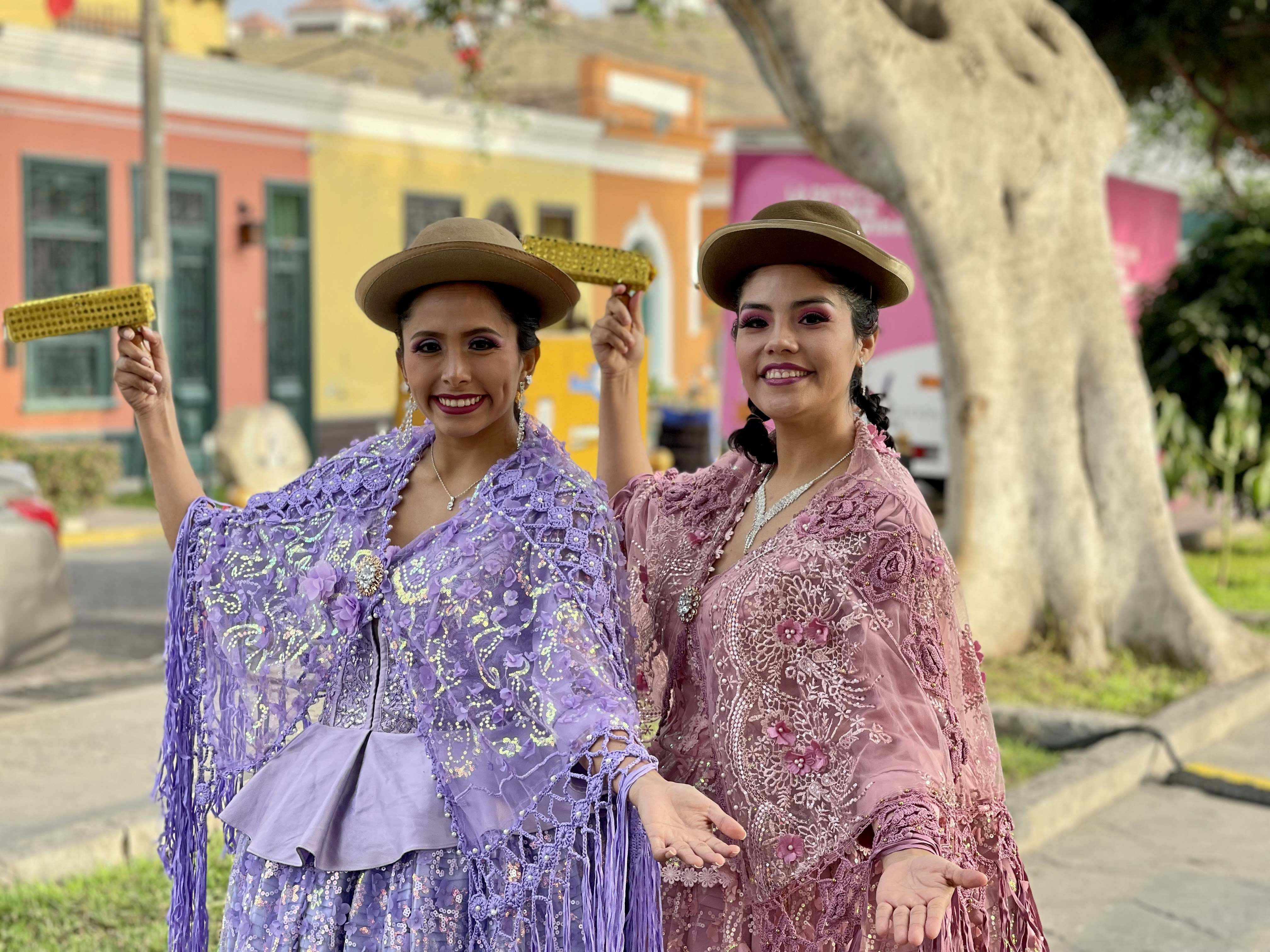 Dos mujeres con ropa tradicional posan felices.