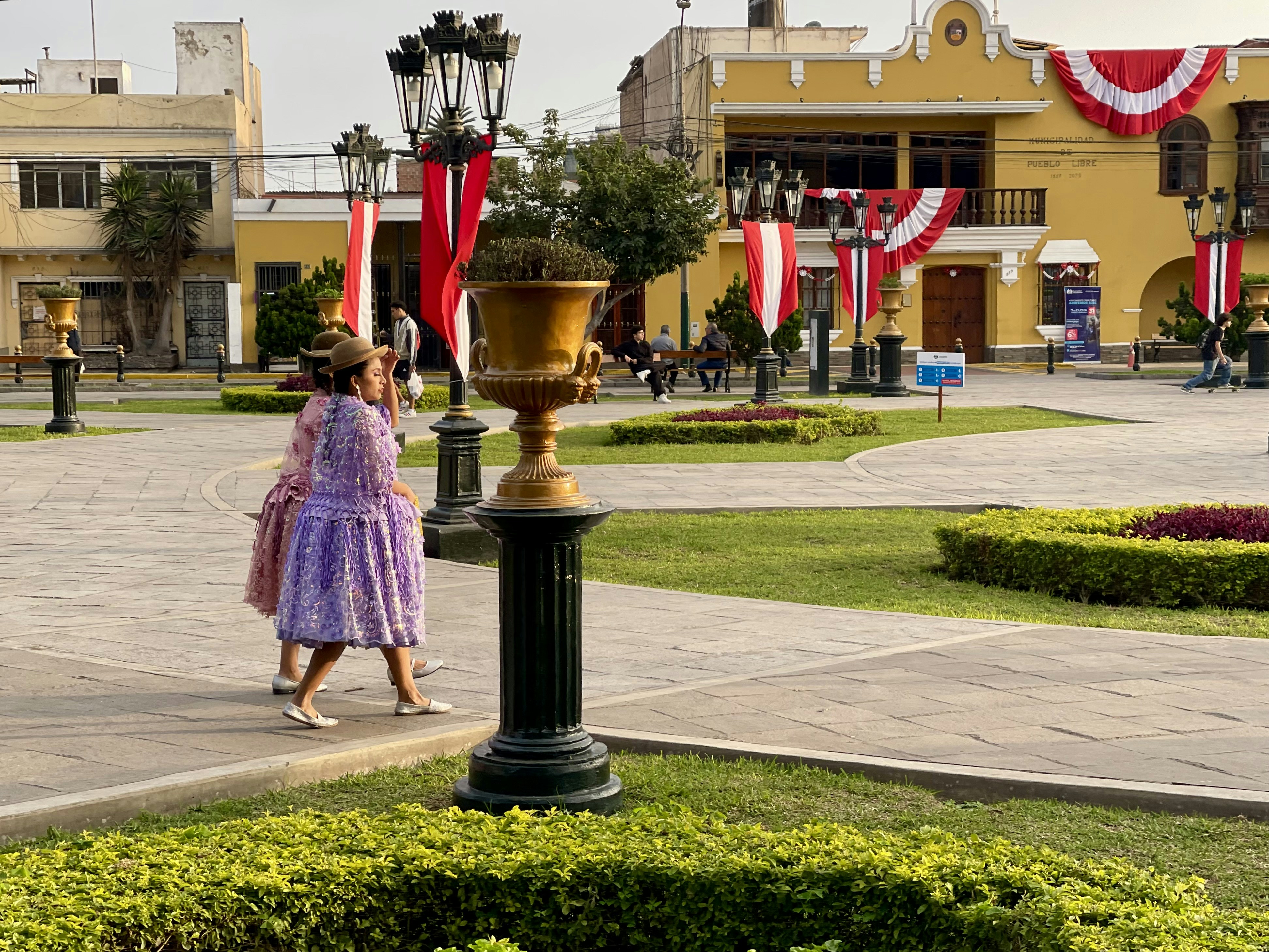 Due donne passeggiano in una piazza colorata.