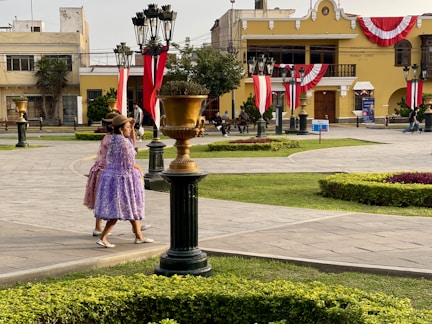 Two women stroll through a colorful plaza.