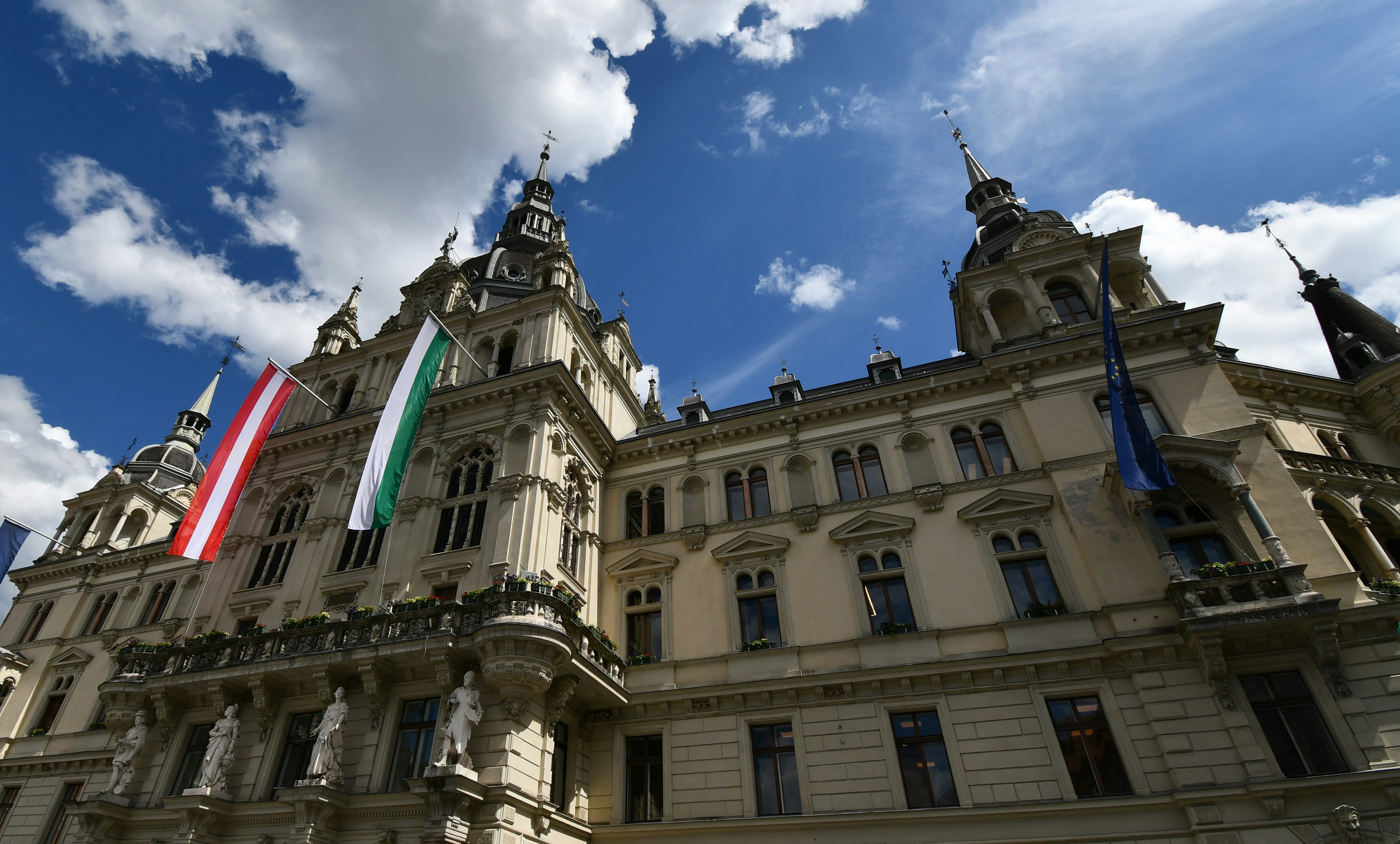The historic city hall stands tall under a blue sky.