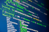 Computer code is displayed on a screen.