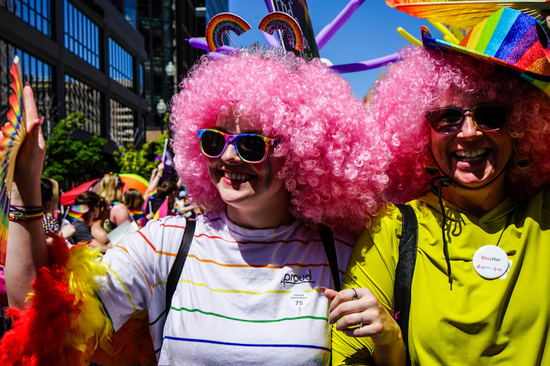 pride goers smiling in colorful wigs