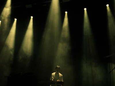 Musician playing keyboard under stage lights