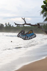 Surf lesson sign hangs above a beach.