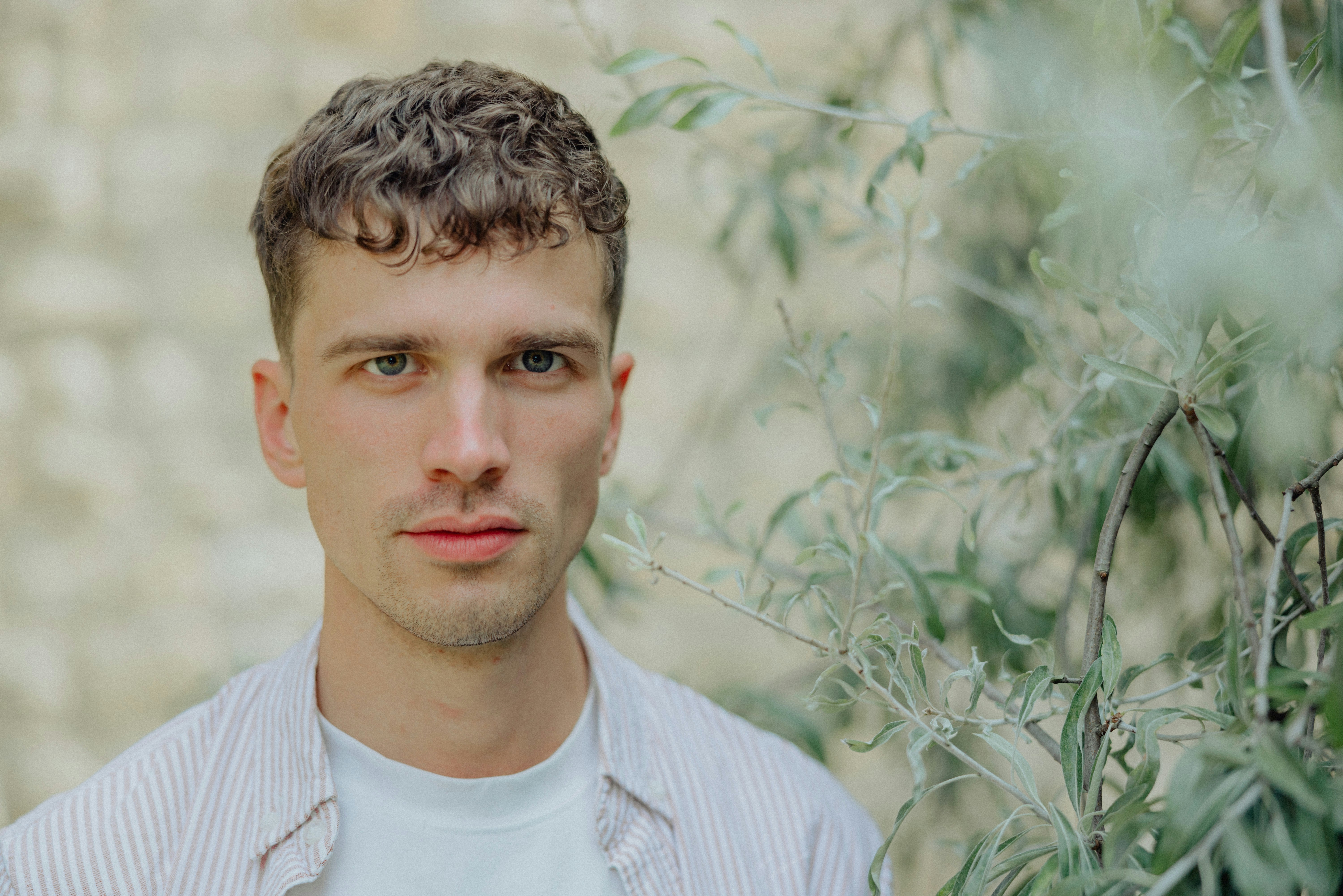 A man poses outdoors, looking directly at the viewer.