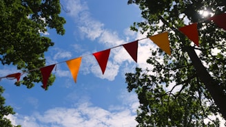 Colorful pennant flags adorn a bright blue sky.