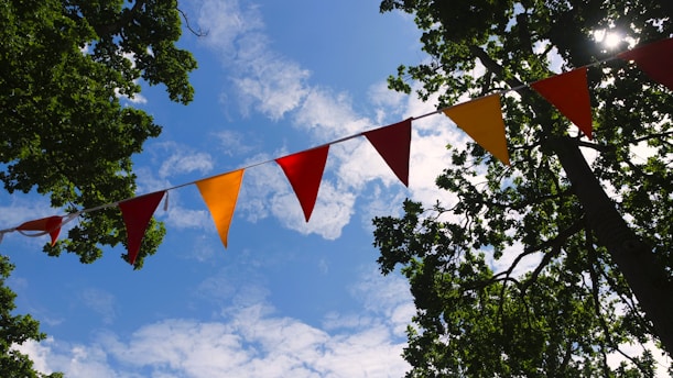 Colorful pennant flags adorn a bright blue sky.