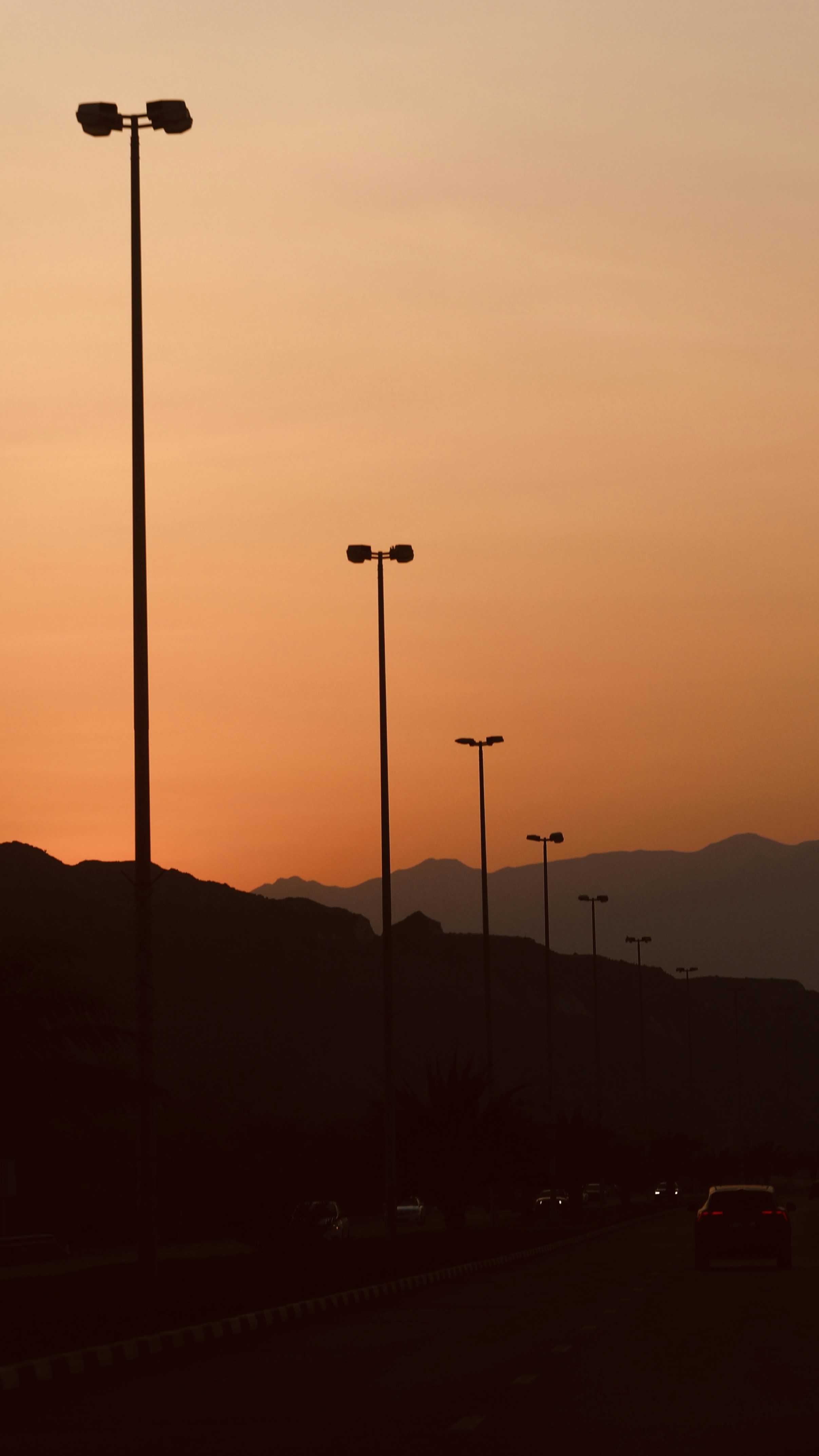La puesta de sol proyecta sombras sobre la carretera y las montañas.