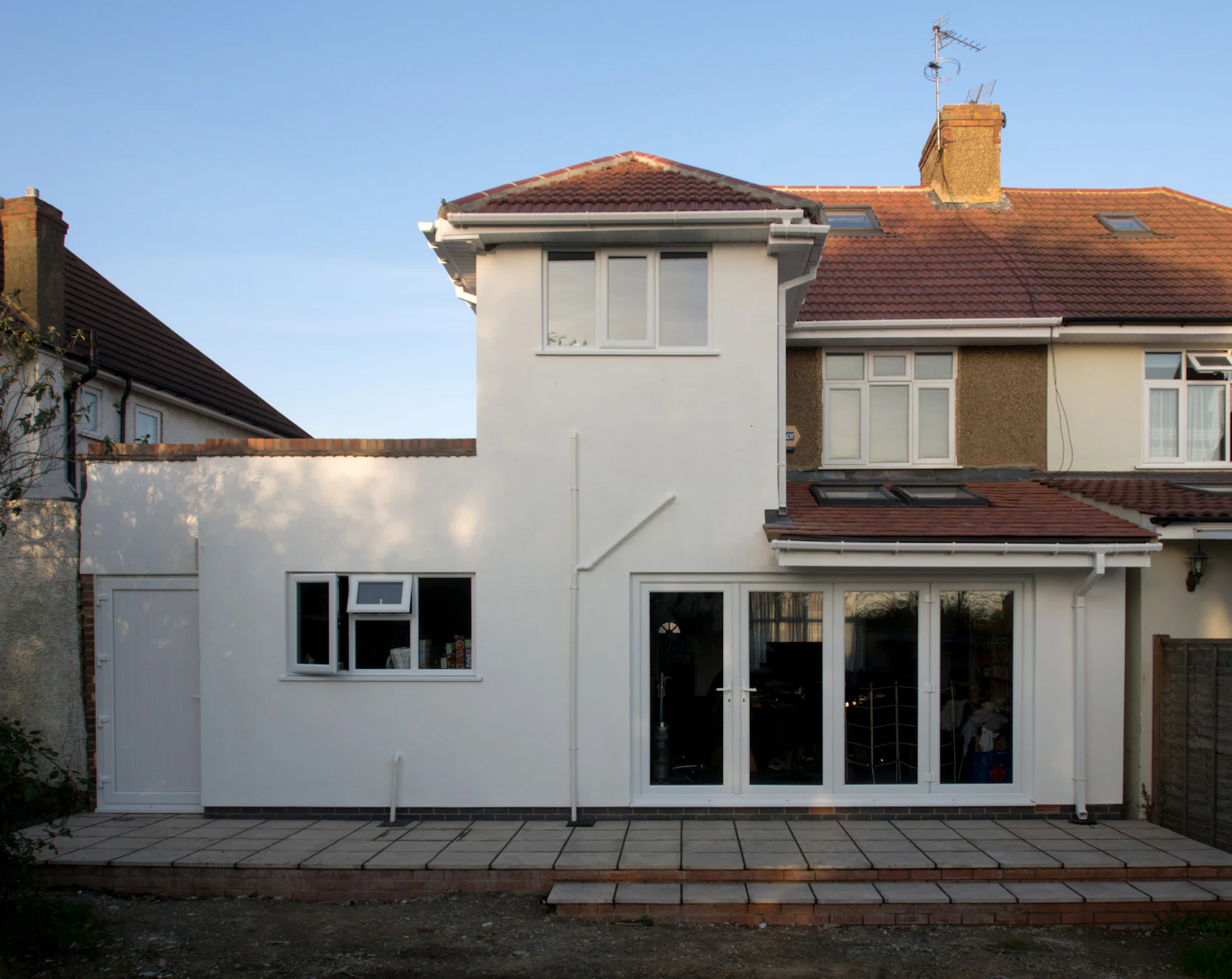 Finished white rendered rear extension with patio doors on a British semi
