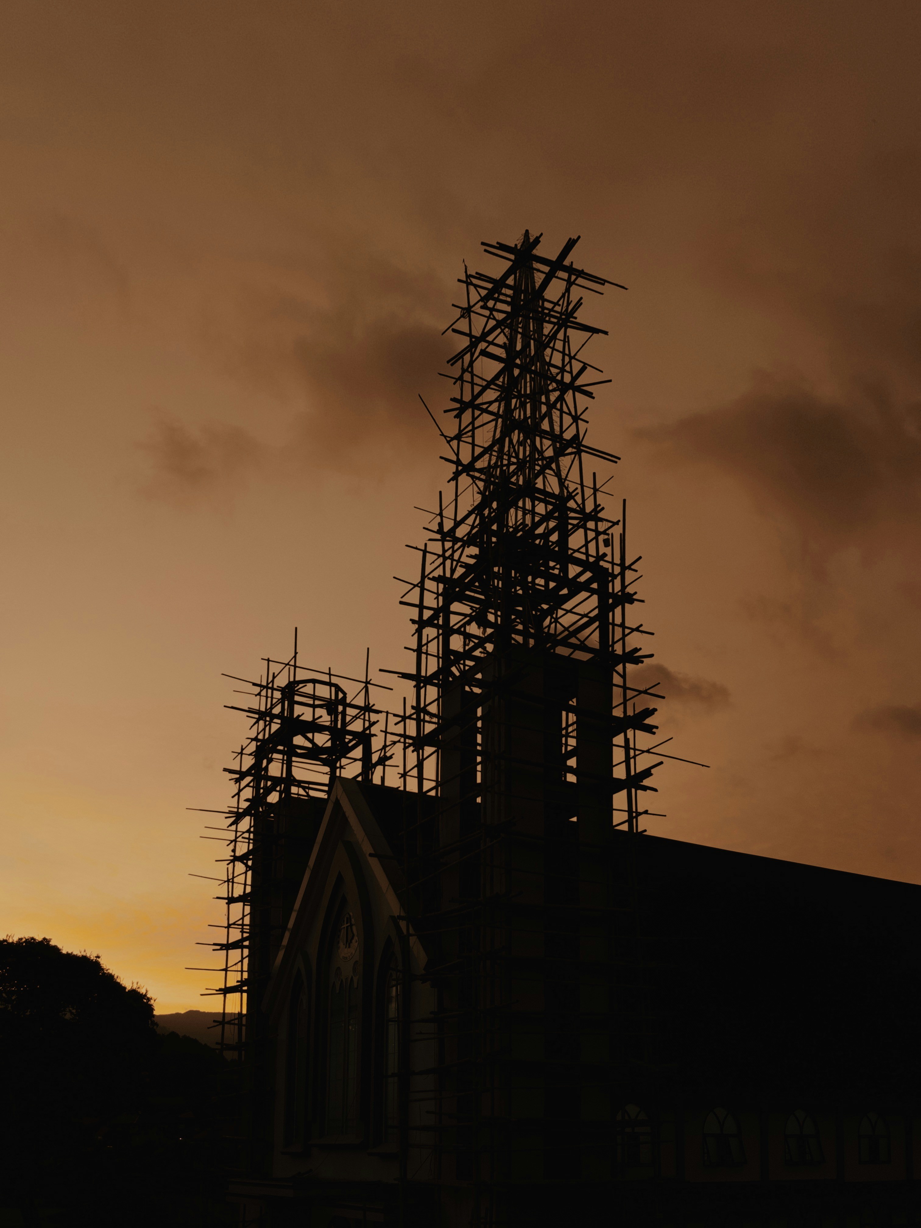 Sebuah gereja bersiluet dengan matahari terbenam keemasan.