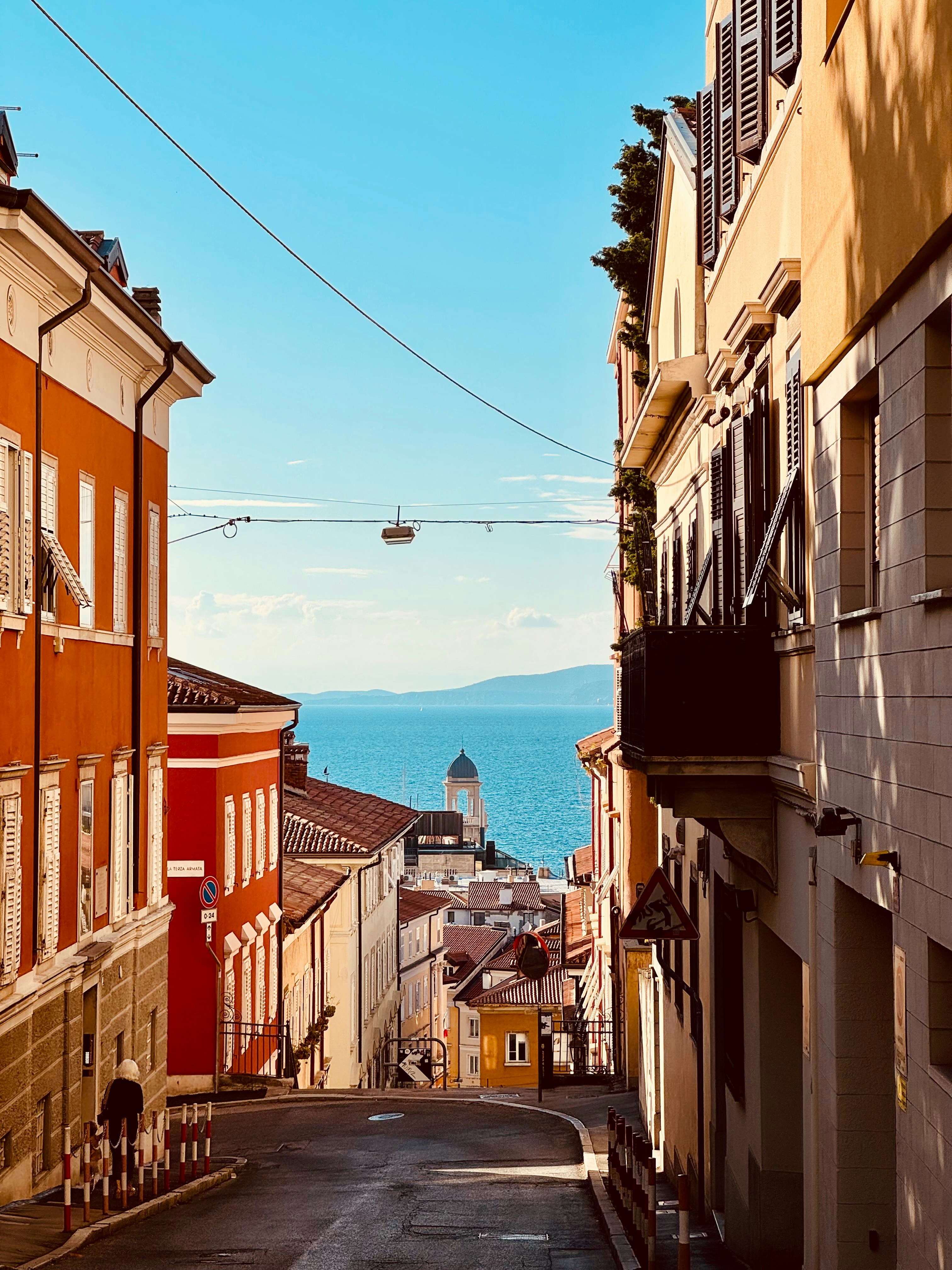 A narrow street leads to the ocean view.