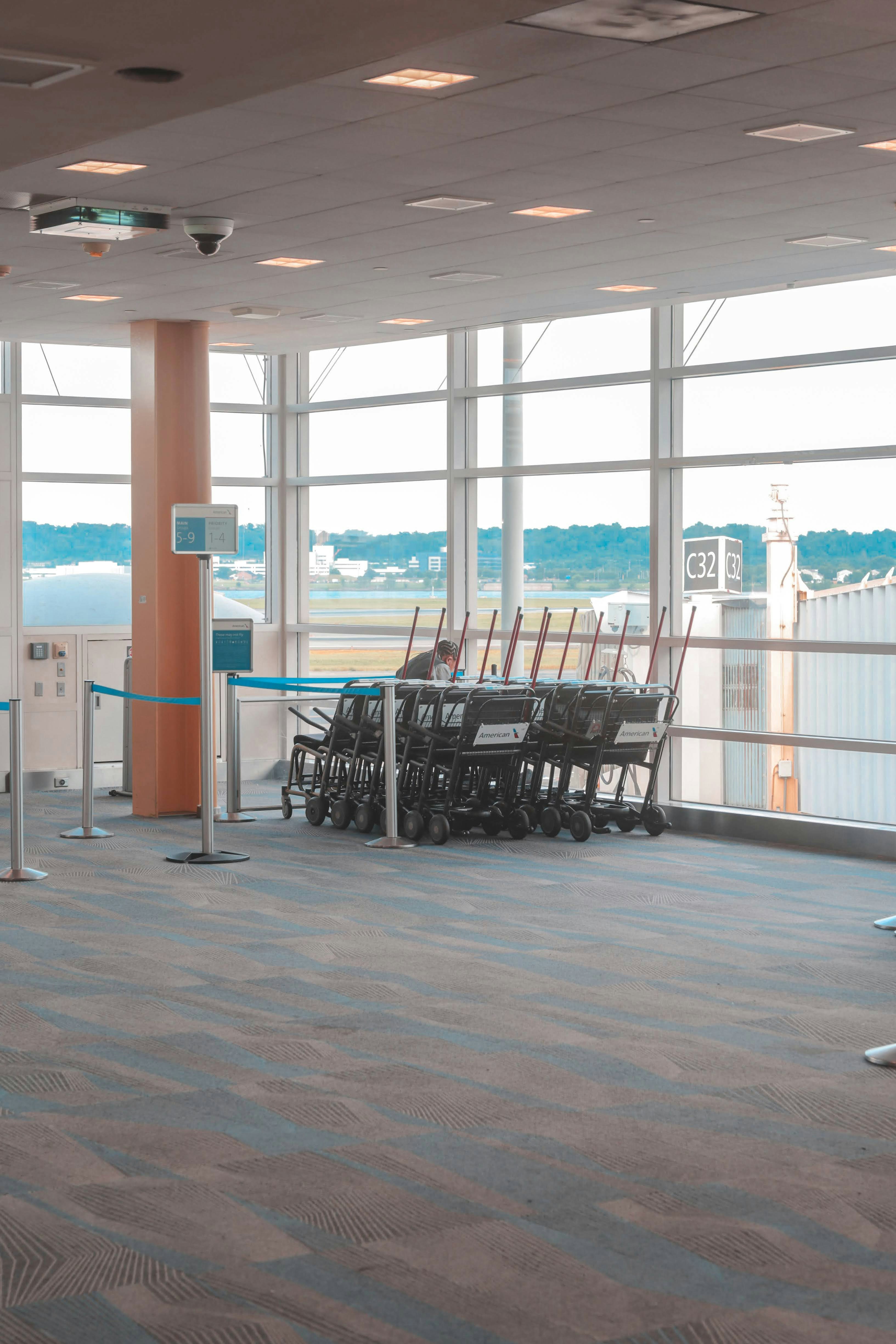 Flughafen mit Gepäckwagen und Fenstern.