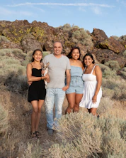 Family posing with dog in a natural landscape