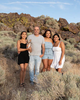 Family posing with dog in a natural landscape